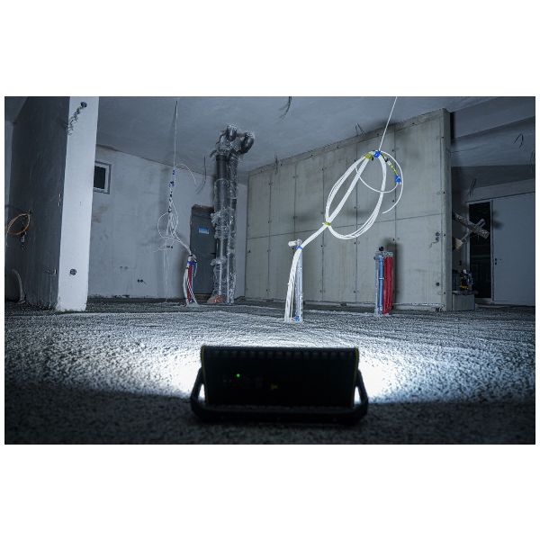 Potente y resistente foco de obra de 8000 lm con luz direccional, temperatura de color ajustable y alimentación híbrida para funcionamiento con batería y cable.